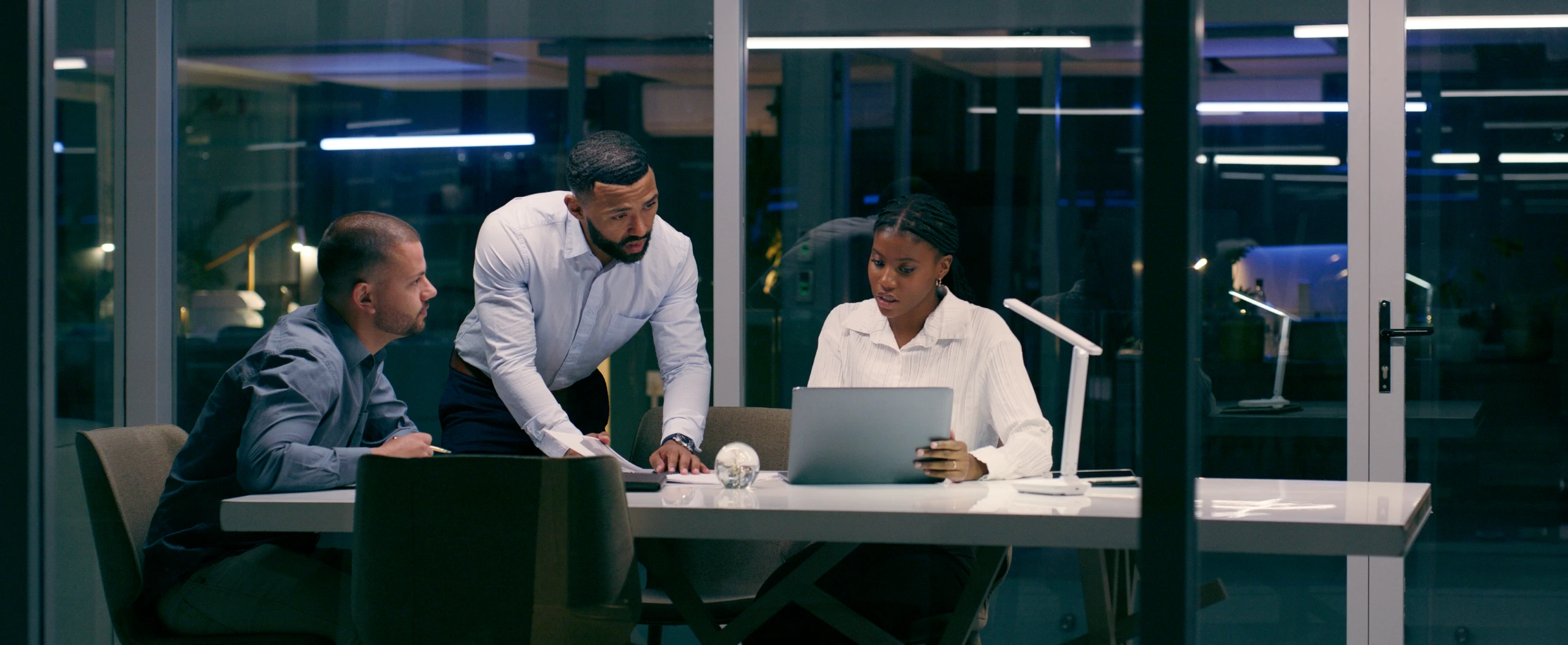 Three colleagues working late at office.
